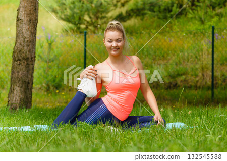 Woman doing exercises gym outdoors in garden 132545588