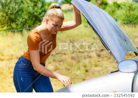 Woman standing near broken down car 132545592