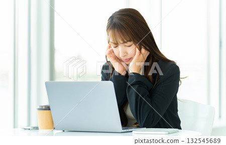 A woman worried while using a computer A woman worried while using a computer 132545689
