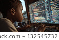 Focused african child coding on computer displaying colorful programming code at home 132545732