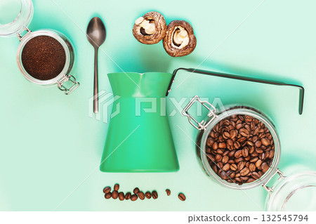Mushroom Coffee, Superfood. Turkish coffee pot, spoon, mushrooms and coffee beans on a mint background. Trendy coffee. Flat lay Mushroom Coffee, Superfood. Turkish coffee pot, spoon, mushrooms and coffee beans on a mint background. Trendy coffee. Flat lay 132545794