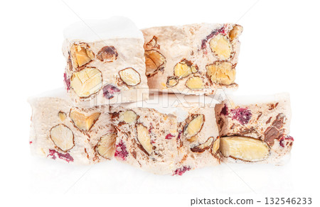 Stack of traditional Italian nougat torrone with almonds and dried cranberries isolated on white background, festive sweet dessert concept 132546233