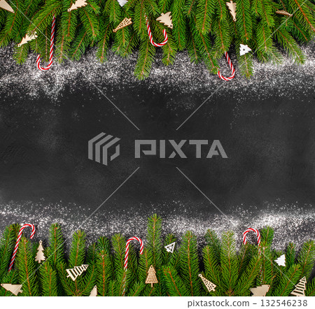 Christmas background with green fir branches, candy canes, and wooden decorations on black surface with powdered sugar snow, festive flat lay with copy space Christmas background with green fir branches, candy canes, and wooden decorations on black surface with powdered sugar snow, festive flat lay with copy space 132546238