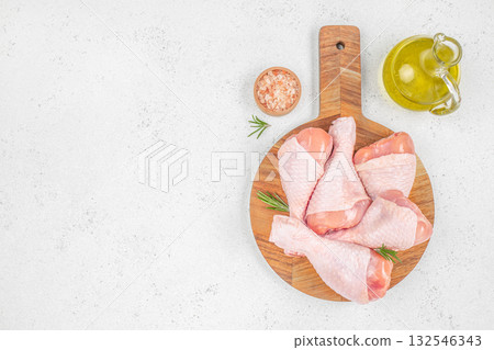 Fresh raw chicken drumsticks with rosemary, pink salt and olive oil on wooden board, premium poultry meat for restaurant menu, barbecue, grill or home cooking Fresh raw chicken drumsticks with rosemary, pink salt and olive oil on wooden board, premium poultry meat for restaurant menu, barbecue, grill or home cooking 132546343