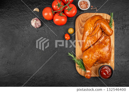 Juicy smoked whole chicken served on a wooden board with fresh rosemary, garlic, tomatoes, pink salt and ketchup, rustic traditional meat dish on dark stone background with copy space Juicy smoked whole chicken served on a wooden board with fresh rosemary, garlic, tomatoes, pink salt and ketchup, rustic traditional meat dish on dark stone background with copy space 132546400