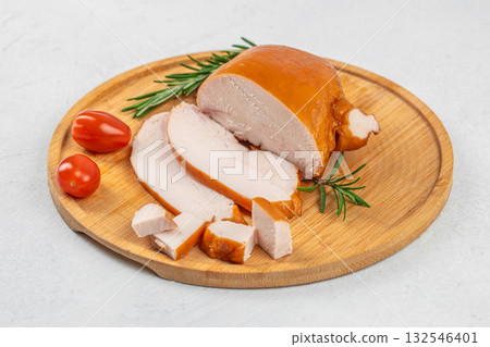 Juicy smoked chicken breast sliced and served on a wooden cutting board with rosemary and fresh tomatoes, delicious lean meat delicacy, rustic culinary presentation on light background Juicy smoked chicken breast sliced and served on a wooden cutting board with rosemary and fresh tomatoes, delicious lean meat delicacy, rustic culinary presentation on light background 132546401