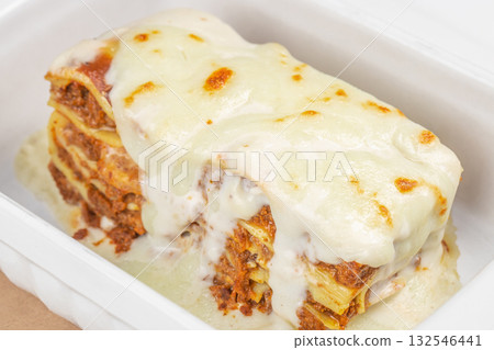 Close-up of baked Italian lasagna with layers of pasta, meat sauce, and melted cheese served in a container 132546441