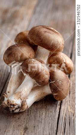 Fresh brown mushrooms arranged on rustic wooden surface for cooking 132546702