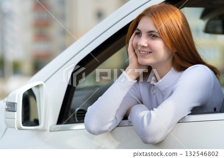 Young woman with red hair driving a car. Young woman with red hair driving a car. 132546802