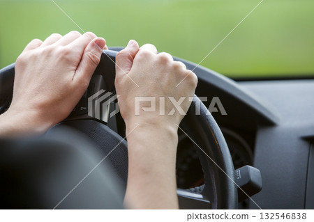 Woman hands on steering wheel driving a car. 132546838
