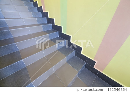 Wide staicase covered with ceramic tiles indoors in a house interior. Wide staicase covered with ceramic tiles indoors in a house interior. 132546864