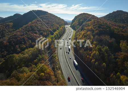 View from above of I-40 freeway in North Carolina heading to Asheville through Appalachian mountains in golden fall season with fast driving trucks and cars. Interstate transportation concept View from above of I-40 freeway in North Carolina heading to Asheville through Appalachian mountains in golden fall season with fast driving trucks and cars. Interstate transportation concept 132546904