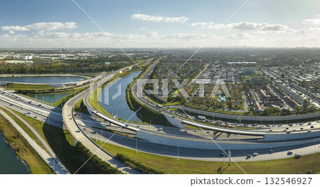 USA transportation infrastructure concept. View from above of american big freeway intersection in Miami, Florida with fast moving cars and trucks USA transportation infrastructure concept. View from above of american big freeway intersection in Miami, Florida with fast moving cars and trucks 132546927