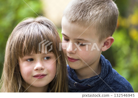 Two cute fair-haired children siblings, young boy brother and sister girl outdoors on bright sunny green bokeh background. Family relation, friendship and love concept. 132546945