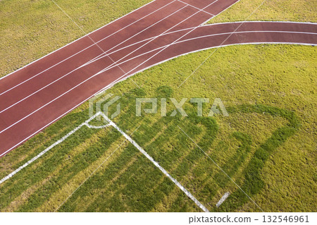 Top view of red running tracks and green grass lawn. Infrastructure for sports activities. Top view of red running tracks and green grass lawn. Infrastructure for sports activities. 132546961
