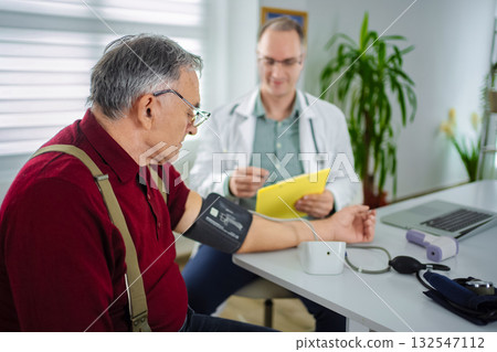 Doctor checks blood pressure of patient in modern clinic setting 132547112