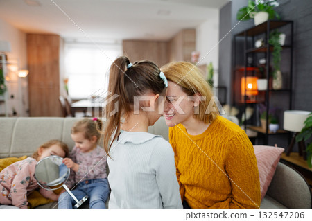 Loving mother spending time with her daughters at home 132547206