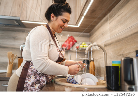 Woman washing dishes in the kitchen Woman washing dishes in the kitchen 132547250