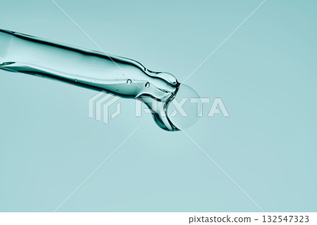 The texture of the serum in a glass cosmetic pipette. Minimalism. The texture of the serum in a glass cosmetic pipette. Minimalism. 132547323