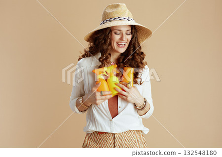 happy elegant housewife in blouse and shorts against beige 132548180