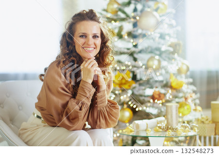 Woman\'s Warm Smile by Golden Christmas Tree 132548273