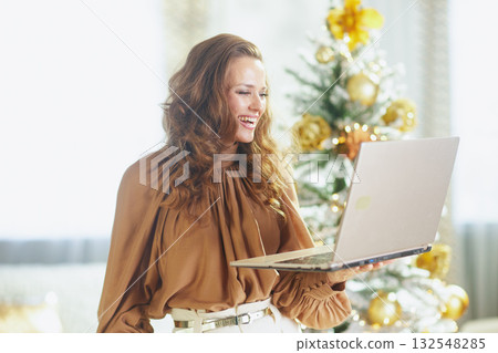 Brightly Smiling Woman Holding Laptop at Christmas 132548285