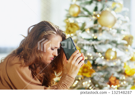 Woman Leaning on Phone in Holiday Distress Woman Leaning on Phone in Holiday Distress 132548287