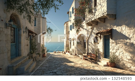 Charming coastal village street with a single twisted tree, leading down a cobblestone path to the bright blue ocean. Rustic Mediterranean architecture featuring white stone walls and wooden doors. 132548593