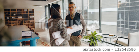 Professionals Engaged in Dynamic Discussion about Project Plans in a Modern Office Space 132548596