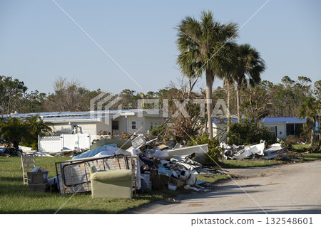Scrap metal disposed in heaps on street side after hurricane severely damaged houses in Florida mobile home residential area. Consequences of natural disaster Scrap metal disposed in heaps on street side after hurricane severely damaged houses in Florida mobile home residential area. Consequences of natural disaster 132548601