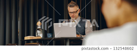 Focused Professional Working in Modern Caf Focused Professional Working in Modern Caf 132548602