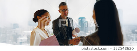 Business Professionals Engaging in a Productive Meeting with a Cityscape Backdrop in View Business Professionals Engaging in a Productive Meeting with a Cityscape Backdrop in View 132548620