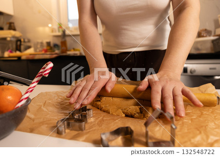 Rolling Gingerbread Dough for Christmas Cookies in Kitchen 132548722