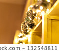 Holiday garland with warm lights on a wooden shelf. 132548811