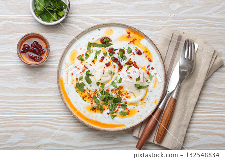 Turkish eggs cilbir, Middle Eastern style breakfast on white wooden background table top view 132548834