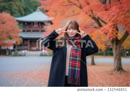 A smiling woman with vibrant autumn leaves in the background A smiling woman with vibrant autumn leaves in the background 132548851
