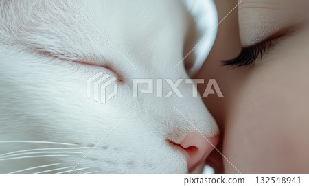 White cat gently touches noses with its owner, their eyes closed in a peaceful embrace, creating a heartwarming scene of companionship and love 132548941