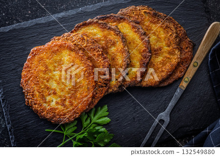 Fried potato pancake on black table. Fried potato pancake on black table. 132549880
