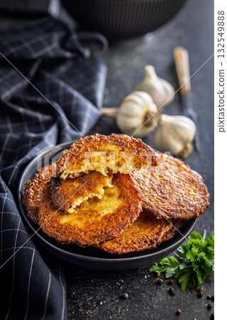 Fried potato pancake on plate on black table. Fried potato pancake on plate on black table. 132549888
