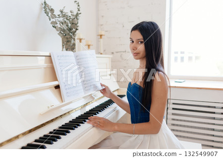 Portrait of a female musician at a white piano Portrait of a female musician at a white piano 132549907