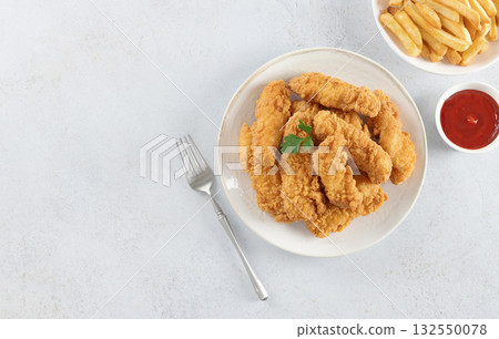 Crispy chicken strips with ketchup and French fries on a white background. Fast food. Copy space Crispy chicken strips with ketchup and French fries on a white background. Fast food. Copy space 132550078