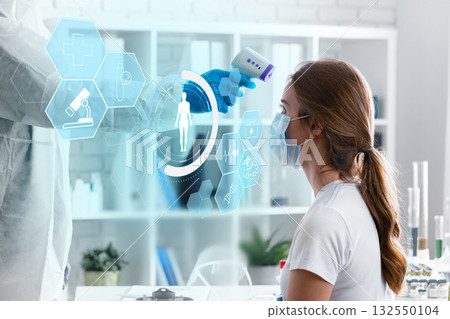 Health professional measuring temperature of patient in modern clinic during health check-up 132550104