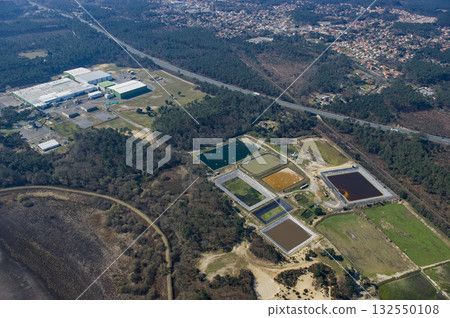 Different colored water ponds at a treatment facility in a natural landscape 132550108