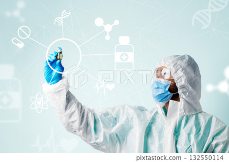 Scientist conducting research in protective gear while holding a vaccine vial 132550114