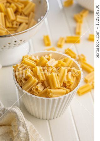 Cinque buchi. Uncooked italian pasta in bowl on white table. 132550230