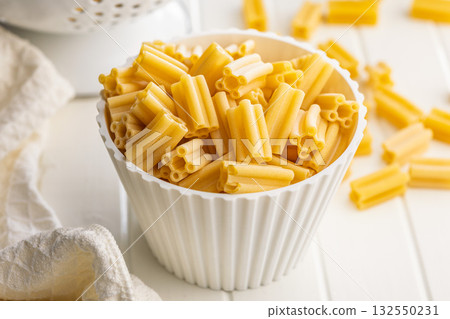 Cinque buchi. Uncooked italian pasta in bowl on white table. Cinque buchi. Uncooked italian pasta in bowl on white table. 132550231