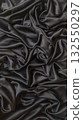Elegant black silk fabric with luxurious folds and flowing drapes texture background 132550297