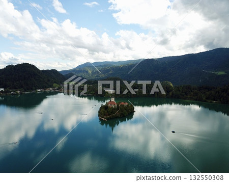 Lake Bled island with Assumption of Mary Church, historic landmark and boats in Slovenia's natural landscape Lake Bled island with Assumption of Mary Church, historic landmark and boats in Slovenia's natural landscape 132550308