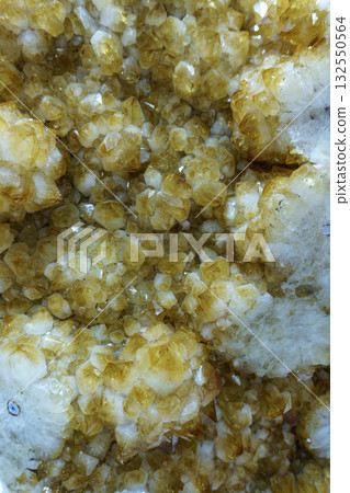 Close-up of a bright yellow citrine - a natural raw gemstone with sparkling facets 132550564