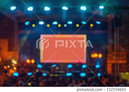 Blurred concert stage with glowing screen and bright lights, creating dynamic atmosphere with copy space for text or branding. Concept of live show, digital display, event 132550602
